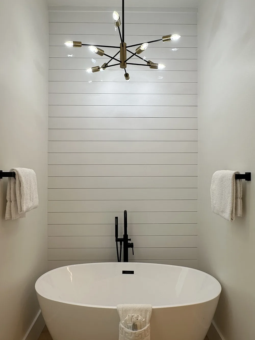 Bathroom with a bathtub and a chandelier